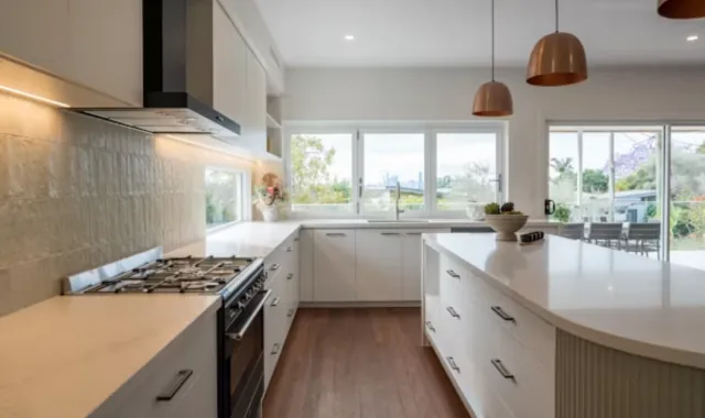 Cuisine d'un logement rénové, plan de travail clair et parquet
