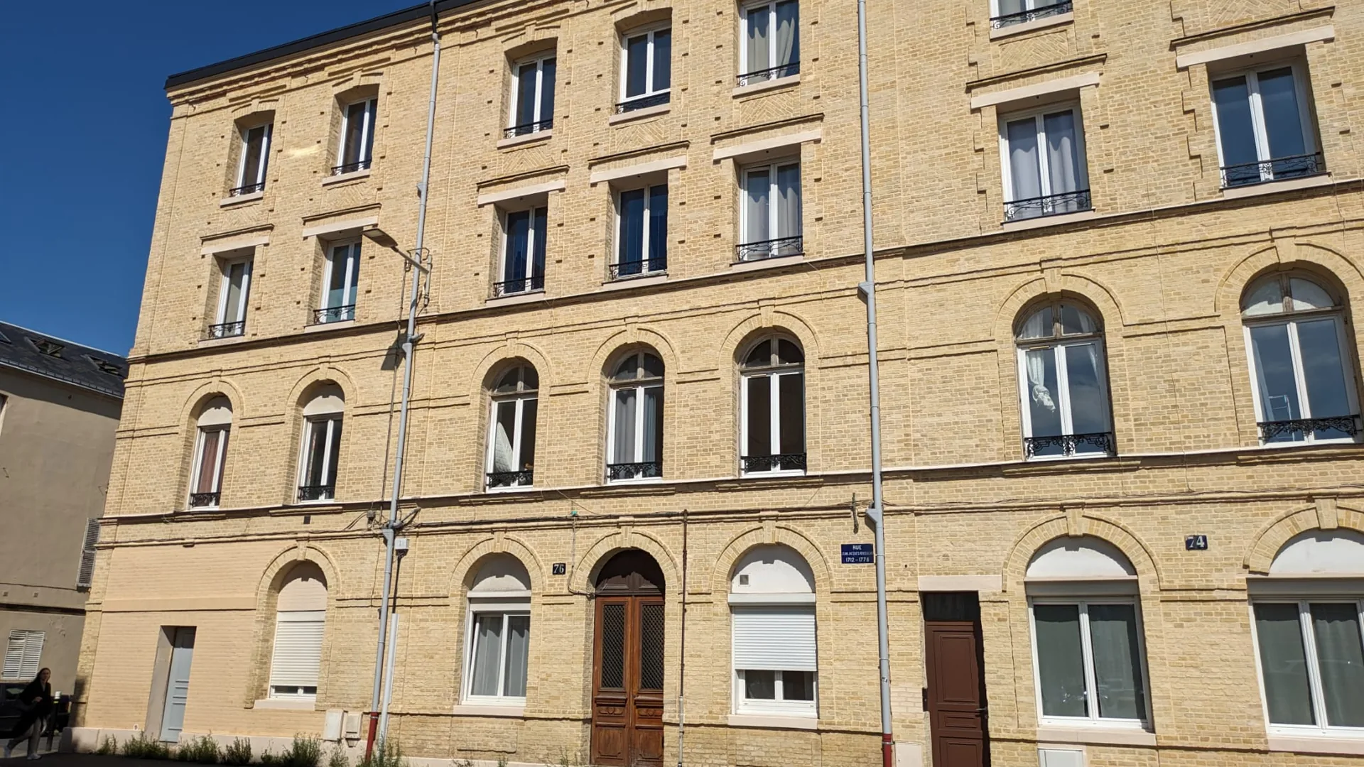 Immeuble de rapport ancien en brique vu depuis la rue, typiquement classé F ou G, où améliorer son DPE conditionne la location